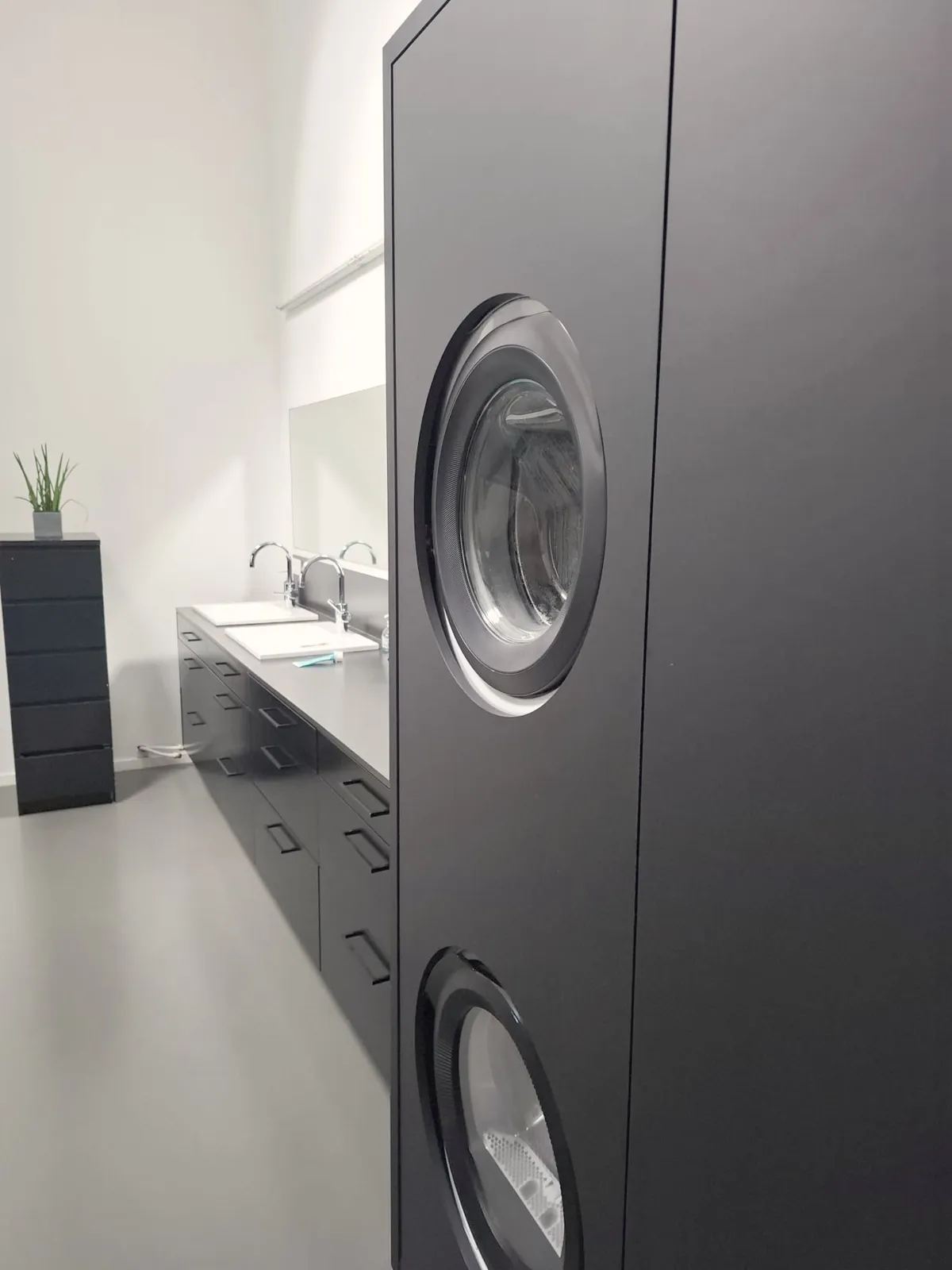 Zwarte kast met ingebouwde wasmachine en droogkast