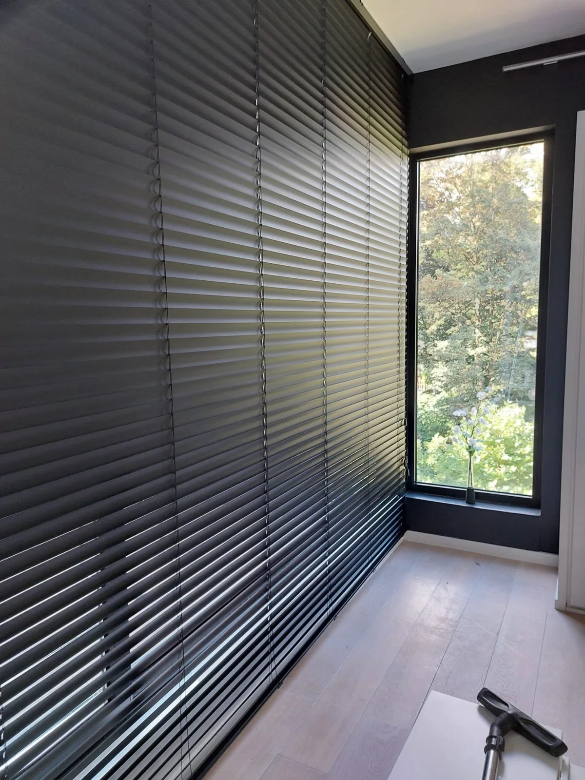Zwarte lamellen dicht over een hele glazen wand