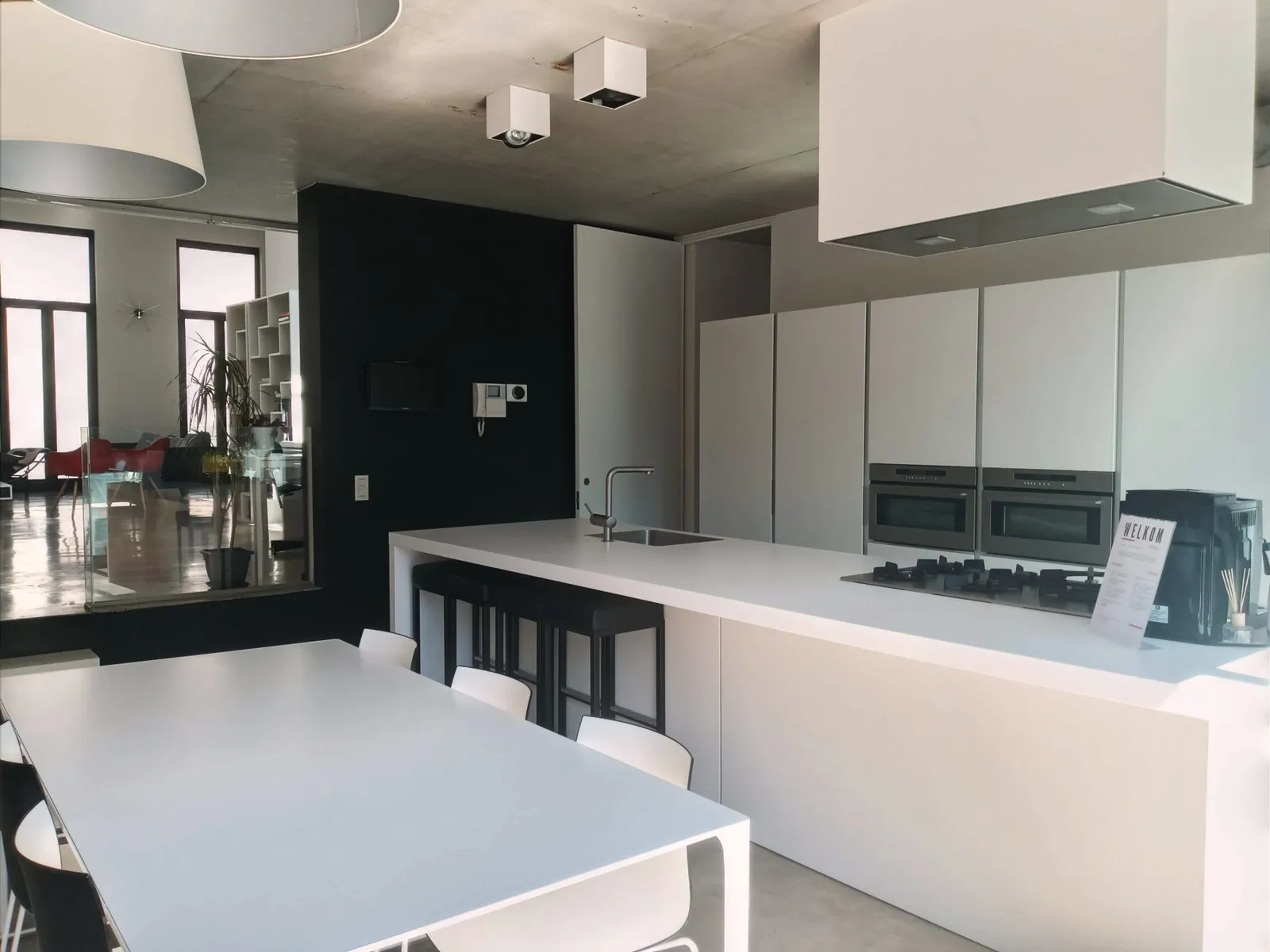 Het witte keukeneiland met de eettafel in daglicht